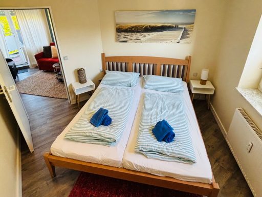 Helles Schlafzimmer mit zwei Einzelbetten, frischen Handtüchern und gemütlicher Einrichtung.