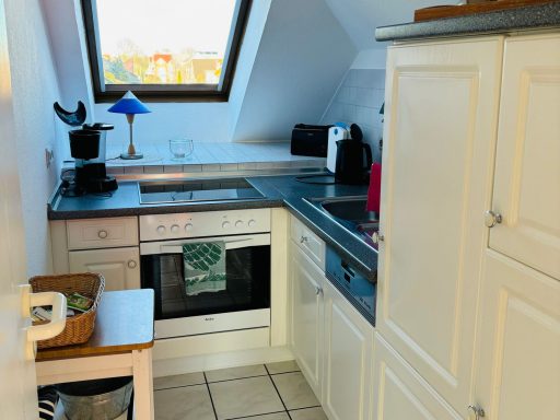 Helle, moderne Küche mit Fenstern, Backofen, Spüle und Küchenzubehör.