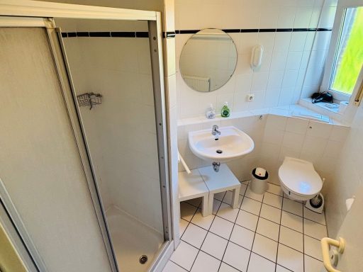 Kleines Badezimmer mit Dusche, Waschbecken und Toilette in hellem Design.