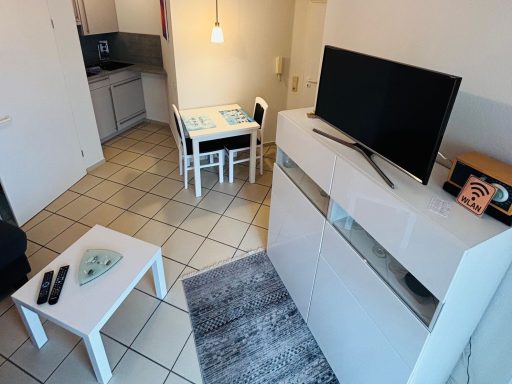 Gemütliche Wohnküche mit Tisch, Stühlen, Sofa und Fernseher.