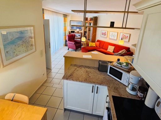 Moderne Wohnung mit offener Küche, Wohnzimmer und farbenfrohen Möbeln.