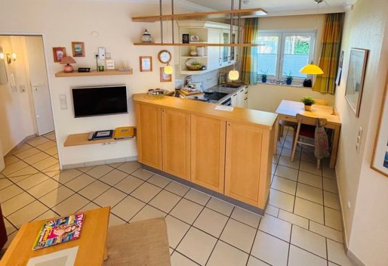 Modern Küche mit Essbereich, Holzmöbeln und großen Fenstern für viel Tageslicht.